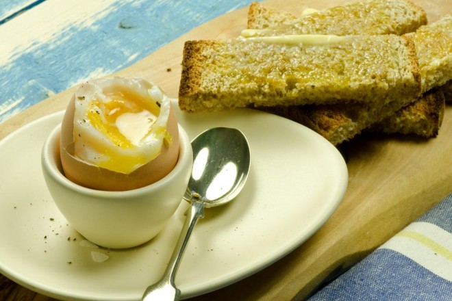 Jajko gotowane na miękko, chleb żytni z masłem, szynką i kiełkami